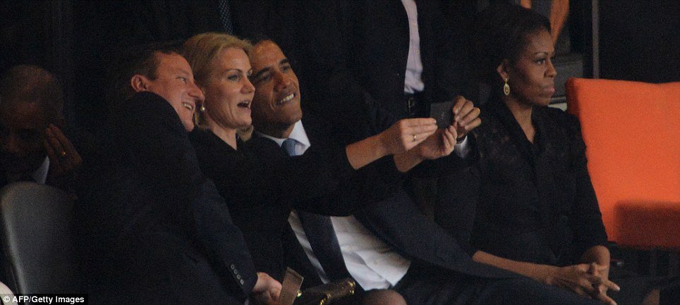 Obama and British Prime Minister David Cameron pose for a selfie photo with Denmark's Prime Minister Helle Thorning Schmidt (center) as First Lady Michelle watches the memorial service 